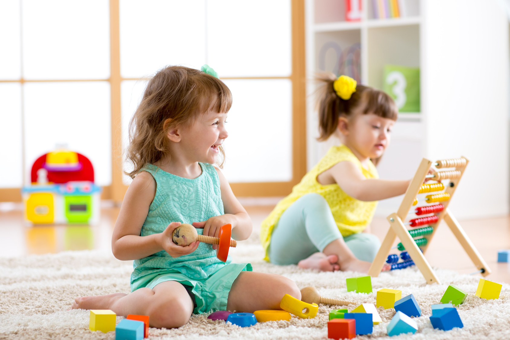 Little kids playing with abacus and constructor toys in kindergarten, playschool or daycare